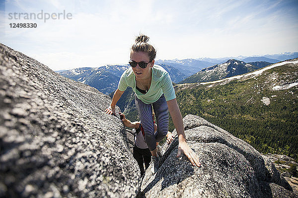 Ein Mann und eine Frau klettern auf ihrem Weg zum Needle Peak  British Columbia  Kanada  auf Granitfelsen.