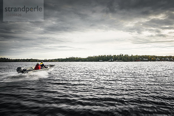 Fischerboot beschleunigt zurück zum Hafen mit bewölktem Himmel auf dem Nipissing-See  Kanada