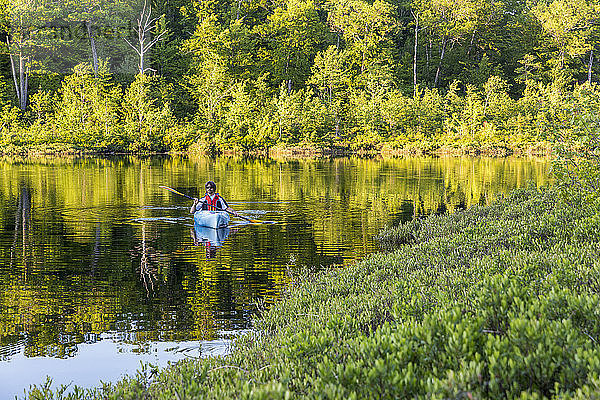 Ein Mann fährt Kajak auf dem runden Teich in Barrington  New Hampshire