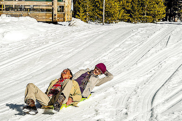 Paar beim Schlittenfahren im Schnee
