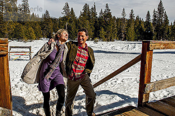 Ein Paar  das auf der Terrasse spazieren geht  mit Schnee im Hintergrund