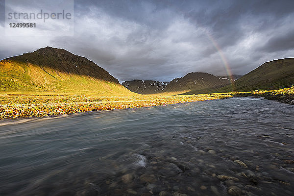 Ein Regenbogen spannt sich über einen Fluss in der Landschaft des Lake Clark National Park und Preserve  Alaska