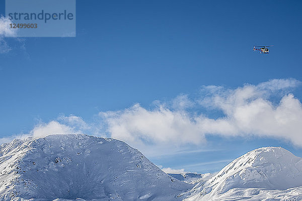 Hubschrauberflug hoch über den verschneiten Bergen am Simplonpass  Schweiz.