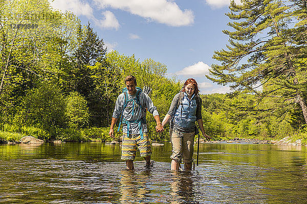 Ein junges Paar Ford der Pleasant River während der Wanderung auf dem Appalachian Trail