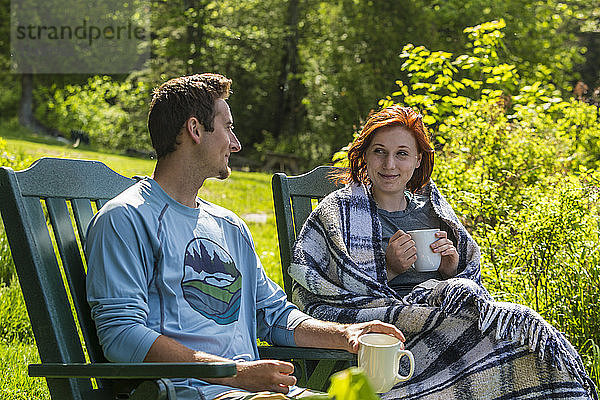 Ein junges Paar genießt seinen Morgenkaffee in der Lodge in der Nähe von Greenville  Maine