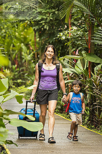 Mutter und kleiner Junge mit Rollkoffer im Tortuguero-Nationalpark