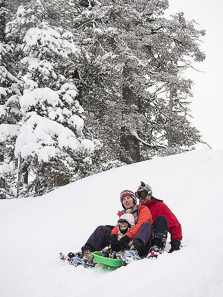 Eltern und Kinder beim Schlittenfahren im Neuschnee vor der Peter Grubb Skihütte  Sierra Nevada