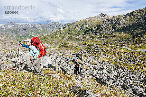 Mann und Frau Wandern auf einem steilen Hügel in Talkeetna Range in Alaska  USA