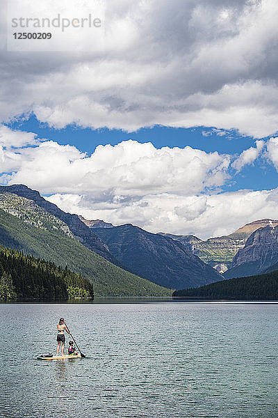 Frau paddelt mit Kind auf dem Bowman Lake im Glacier National Park