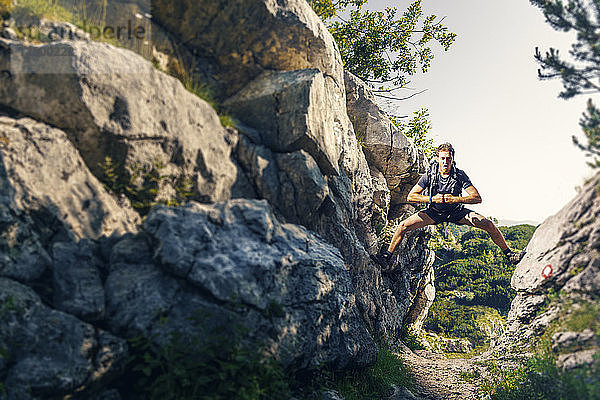 Mann spreizt Bein an zwei Felswänden im Durmitor-Nationalpark