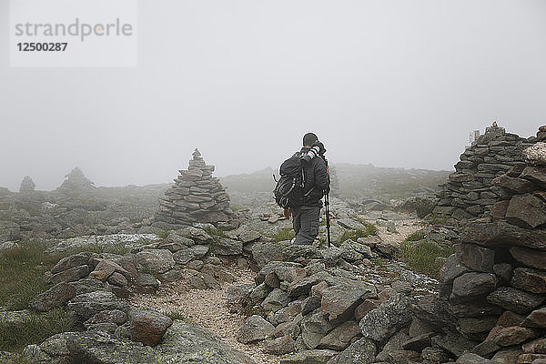 Fotograf beim Wandern auf dem Mount Washington während einer starken Wolkendecke