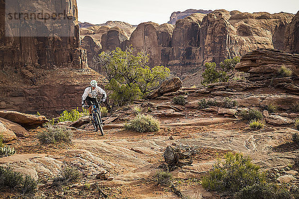 Ein Mann fährt Mountainbike auf dem Hymasa Trail  Moab  Utah.