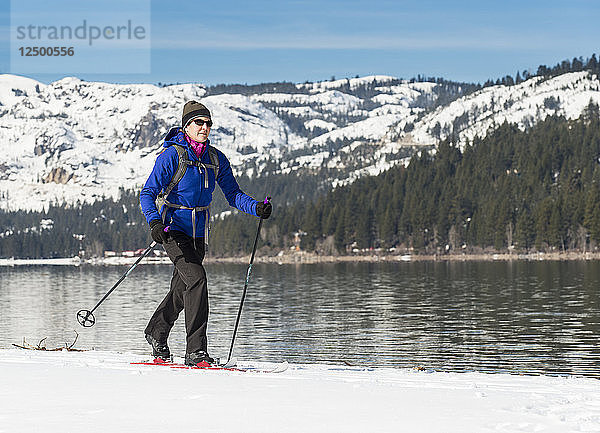 Frau beim Skifahren entlang des Ufers des Donner Lake
