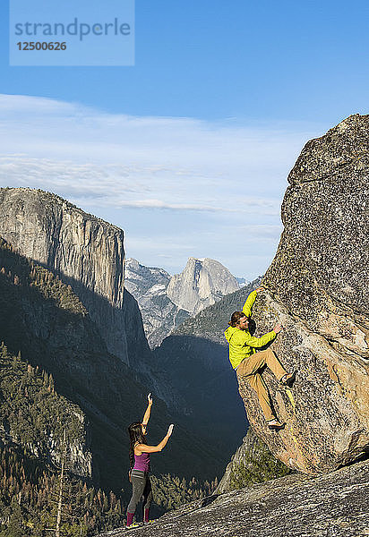 Kletterer Bouldern auf Felsen in Yosemite mit Half Dome und El Capitan im Hintergrund