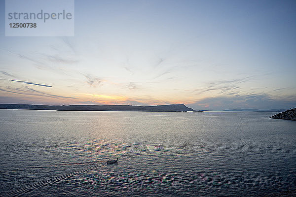 Fischer auf seinem Boot bei Sonnenuntergang im Adriatischen Meer