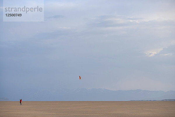 Ein erwachsener Mann lässt einen Drachen in der Alvord-Wüste im Südosten von Oregon steigen