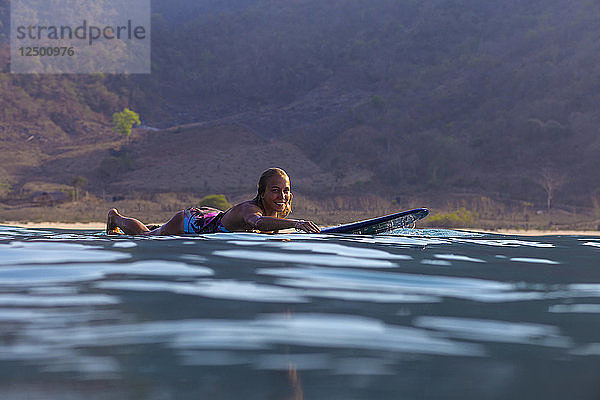 Surfer mit einem Brett im Wasser. West Sumbawa.Indonesien.Indonesien