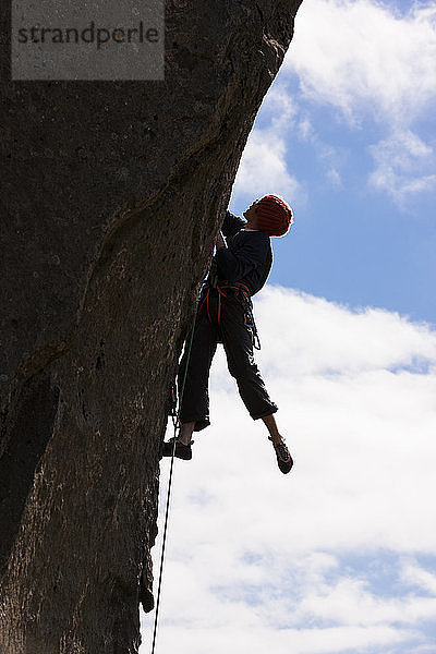 Mann beim Klettern an einem steilen Felsen im Klettergebiet Hnappavellir  Südostisland.
