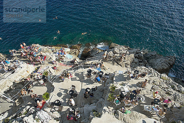 Sonnenanbeter und Schwimmer genießen ein Erholungsgebiet außerhalb der Stadtmauer von Dubrovnik  Kroatien
