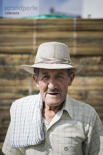 Das Porträt eines älteren kolumbianischen Mannes  der in die Kamera schaut und einen traditionellen Hut trägt