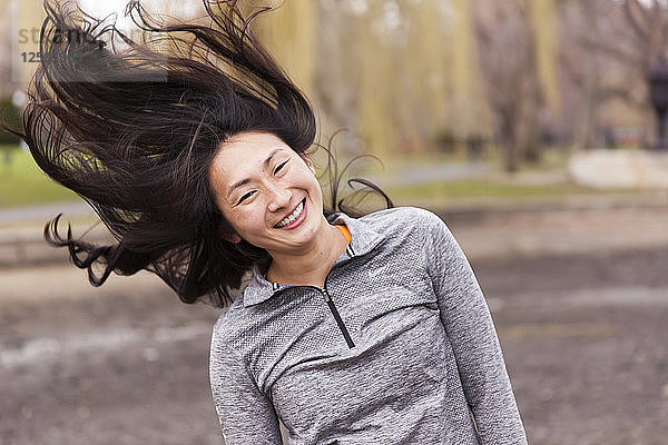 Porträt einer glücklichen Frau  die im Park springt