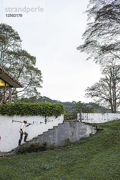 Ein Mann geht eine Treppe auf einem Bauernhof im ländlichen Kolumbien hinauf.