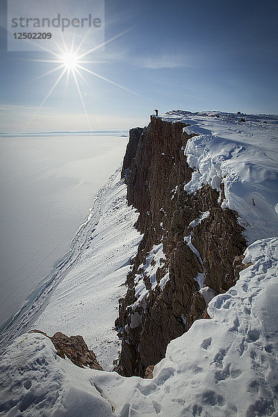 Lange Belichtung von Person stehend auf verschneiten Klippe in Arctic Bay