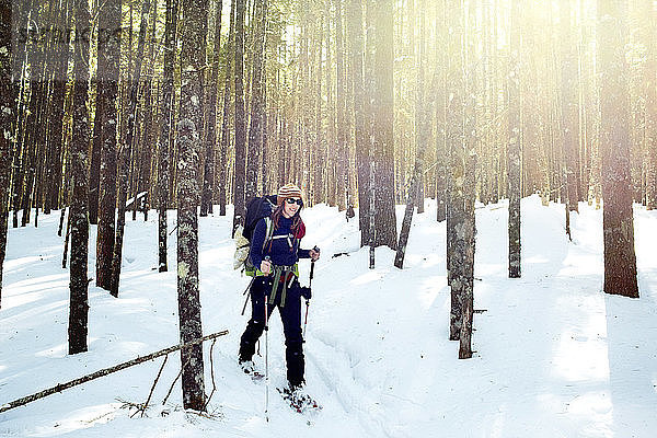 Eine junge Frau geht mit Schneeschuhen durch den Baxter State Park.