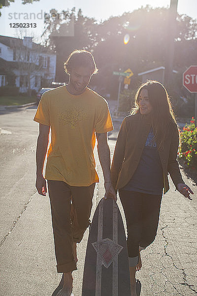 Ein junger Mann und eine Frau gehen in einem Viertel von San Diego spazieren. Kalifornien.