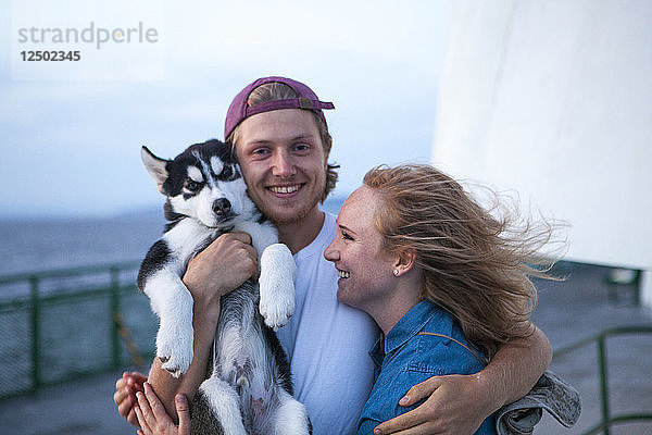 Junge Erwachsene und Husky-Welpe auf einer Fähre