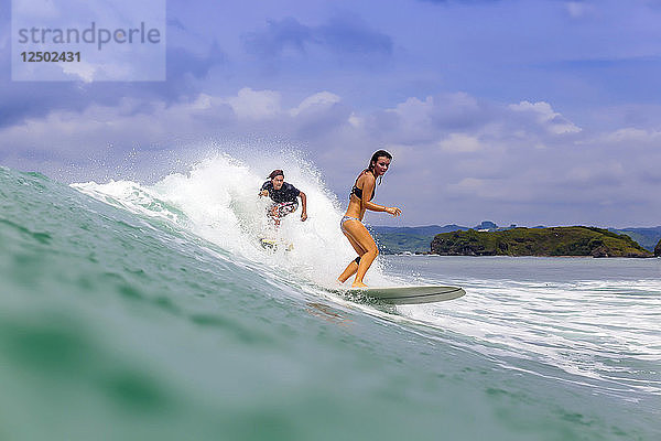 Zwei junge Leute beim Surfen