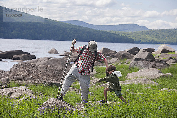 Ein vierjähriger Junge spielt mit seinem Vater an der Black Bear Cove am Aziscohos Lake in Lincoln Plantation  Maine.