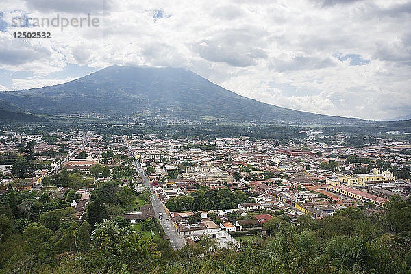 Blick auf die Stadt Antigua mit der Spitze des Volcan De Agua von Wolken im Hintergrund bedeckt