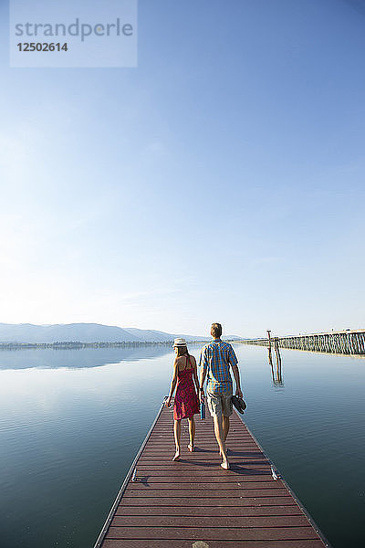 Rückansicht des Paares zu Fuß auf Dock mit Blick auf Lake Pend Oreille  Sandpoint  Idaho