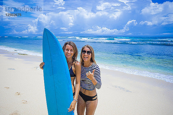Ein paar glückliche Mädchen mit Surfbrett.