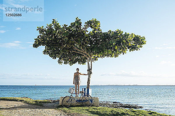 Ein Mädchen steht neben einem Baum in Playa Larga  Kuba
