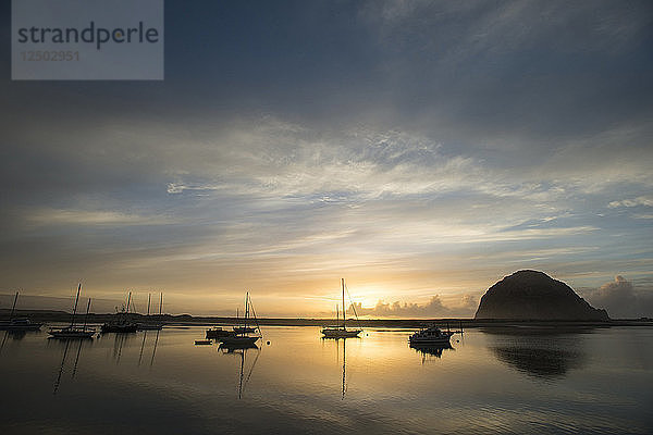 Die Sonne geht am 2. März 2014 über der Morro Bay  Kalifornien  unter. Die Bucht ist nach dem abgebildeten Morro Rock benannt  einem vulkanischen Pfropfen  der eine von neun ähnlichen Formationen ist  die sich an der Küste von Mittelkalifornien landeinwärts ausbreiten.