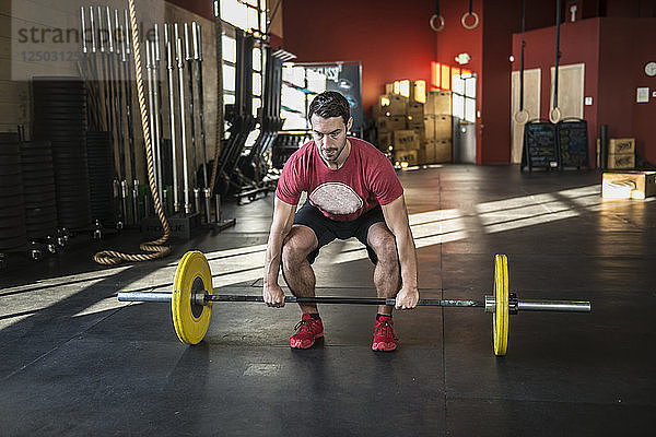 Ein Mann stemmt Gewichte in einem Crossfit-Fitnessstudio.
