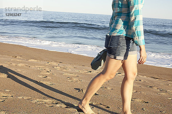 Frau geht am Strand des Reid State Park spazieren
