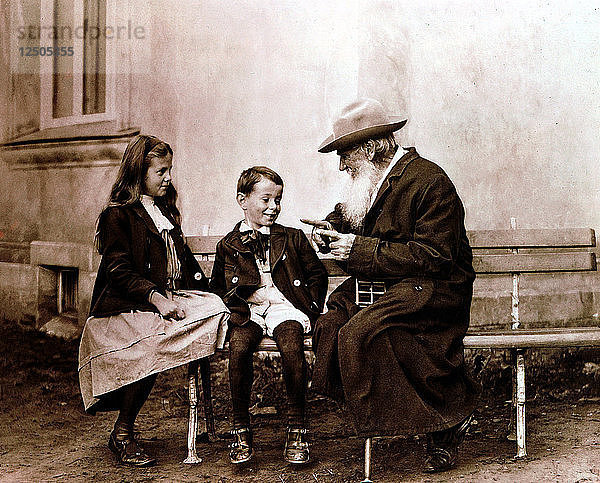 Leo Tolstoi  russischer Schriftsteller  Philosoph und Mystiker  erzählt seinen Enkelkindern eine Geschichte  um 1890-1910. Künstler: Unbekannt
