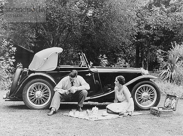 Pärchen beim Picknick neben einem MG TA Midget  Ende der 1930er Jahre. Künstler: Unbekannt