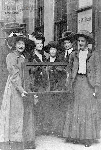 Fünf Suffragetten halten ein zerbrochenes Fenster in seinem Rahmen  1912. Künstler: Unbekannt