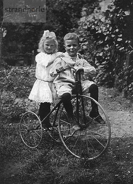 Zwei Kinder auf einem Dreirad  1911-1912.Künstler: CW Perry