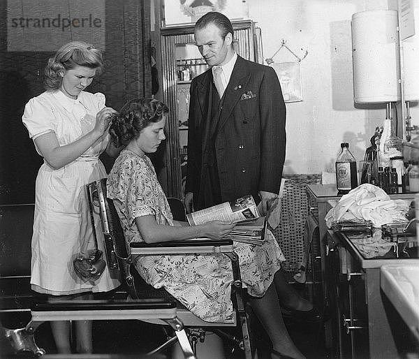 Ein Mädchen  das die Prüfung zur Friseurin vor einem männlichen Prüfer ablegt  Schweden  um 1940-1959. Künstler: Unbekannt