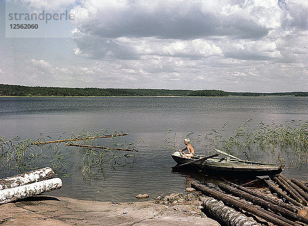 Ein Junge angelt in den Sommerferien von einem Ruderboot aus  Schweden  1950er Jahre. Künstler: Göran Algård