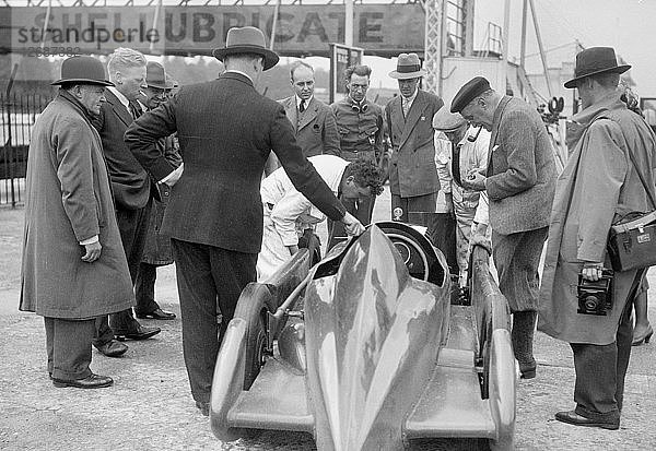 Menschen  die Leon Cushmans Austin 7 Rennwagen in Brooklands für einen Geschwindigkeitsrekordversuch untersuchen  1931. Künstler: Bill Brunell.