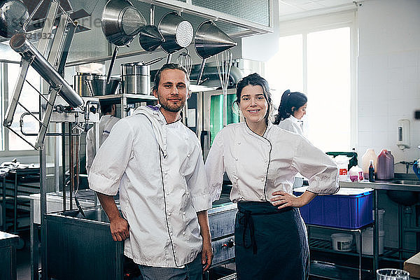 Portrait of confident chefs standing in commercial kitchen