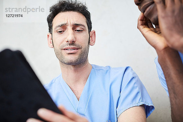 Low angle view of male nurses discussing over digital tablet at hospital