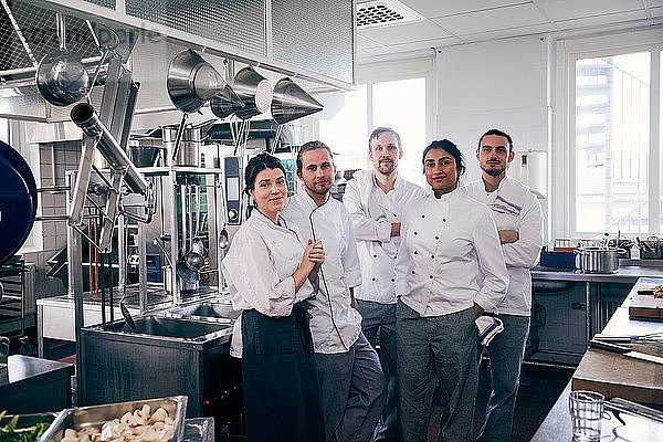 Portrait of chefs standing together in commercial kitchen