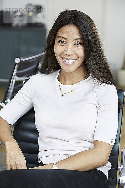 Portrait of smiling businesswoman sitting on chair at office